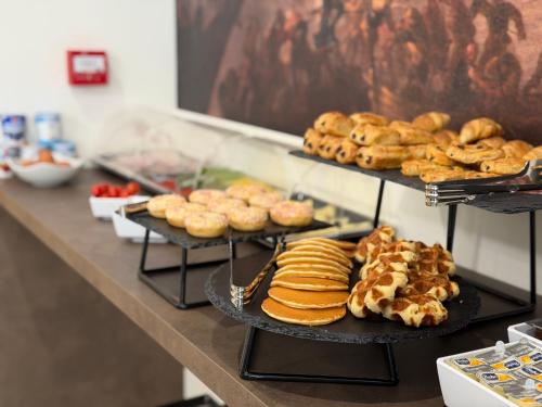 a counter with plates of pastries and other pastries at Lepanto Guesthouse in Misraħ Il-Barrieri