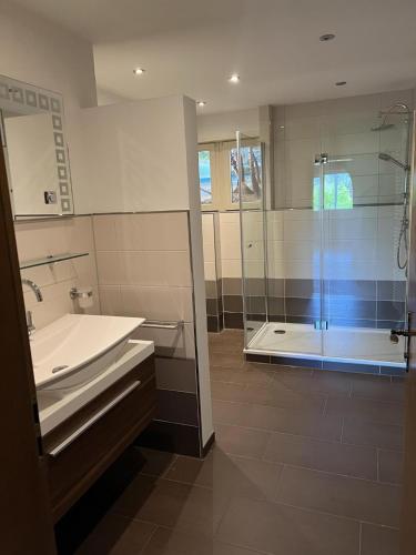 a bathroom with a tub and a sink and a shower at Ferienhaus Samy - Feldberg in Feldberg