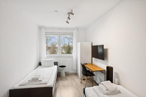 a white room with a bed and a desk at Am Ring Monteurzimmer Apartment Böhlen in Böhlen