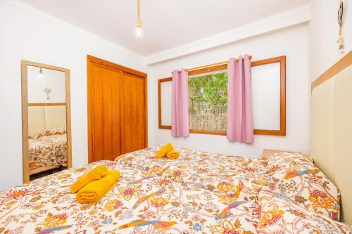 a bedroom with a bed with yellow pillows on it at Apartamento Felipe 1-3 in Cacla D'or
