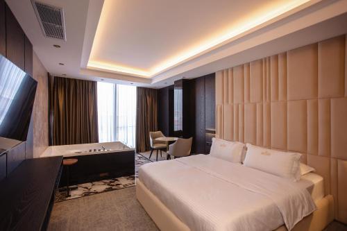 ein Hotelzimmer mit einem großen Bett und einem Schreibtisch in der Unterkunft Hotel Chicago in Shkodra