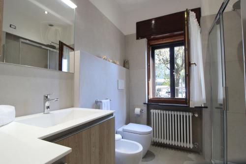 a bathroom with a sink and a toilet and a window at House Angy in Ponte nellʼAlpi