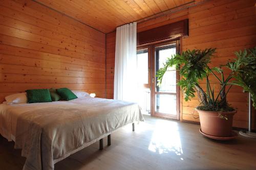 a bedroom with a bed in a wooden wall at House Angy in Ponte nellʼAlpi