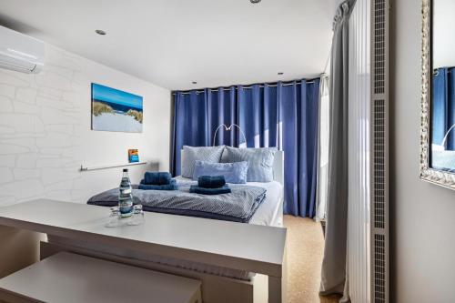 a bedroom with a bed with blue curtains at Ferienhaus am See mit Boot in Mustin