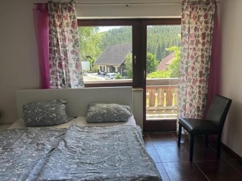 a bedroom with a bed and a chair and a window at Ferienhaus Samy - Feldberg in Feldberg