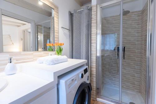 a washing machine in a bathroom with a shower at Sibilla house 2 in Olbia