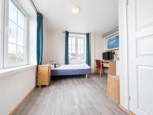 a room with a bed and a desk and windows at Hotel Toranes in Mo i Rana