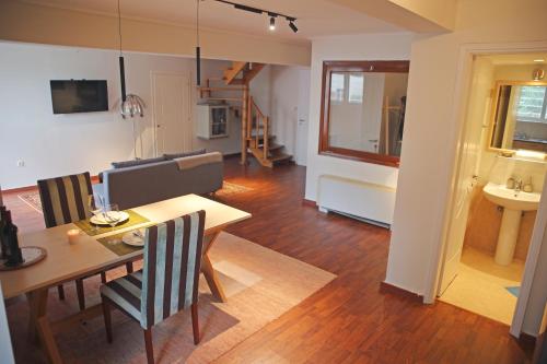 a dining room and living room with a table and chairs at Anavyssos Riviera Cozy Bee Home Maisonette in Anavyssos