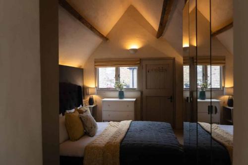 a bedroom with two beds and two windows at The Nook in South Cerney