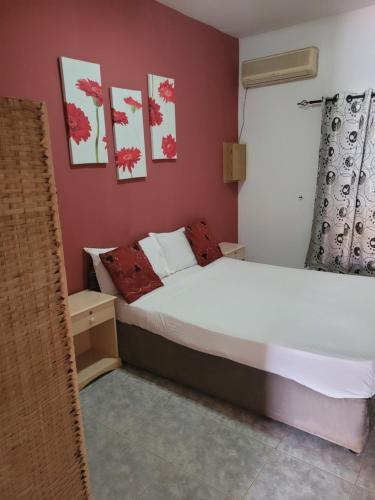 a bedroom with a white bed and red walls at Dandimayo Hotel Bar & Restaurant in Serekunda