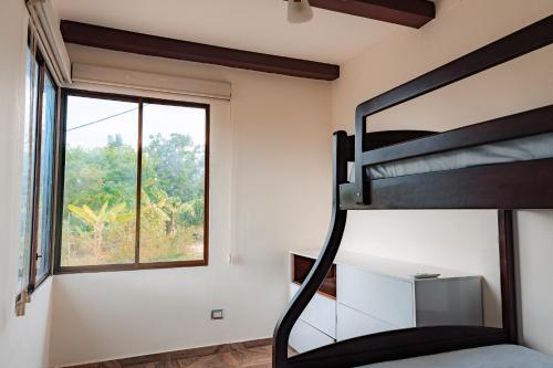 a bedroom with a bunk bed and a window at Finca La Macarena, Playas Villamil in Playas