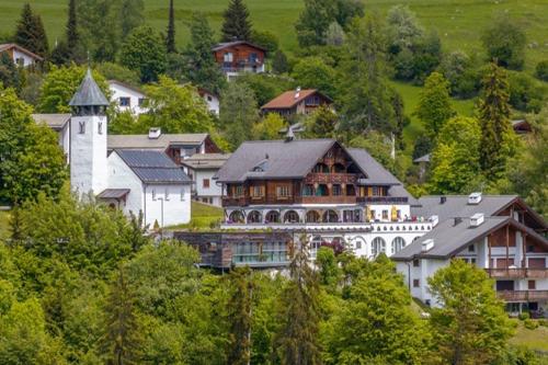 a large house on top of a hill with trees at FidazerHof in Flims