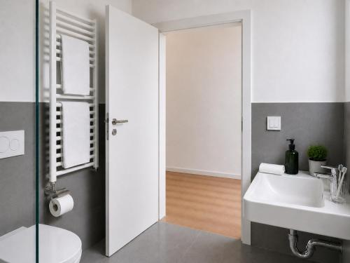a bathroom with a sink and a toilet and a mirror at SleepySleepy Hotel Fulda in Fulda
