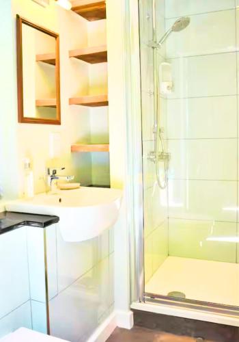a bathroom with a sink and a shower at Rural Cottage Retreat, Near Goodwood Festival of Speed, Dog Friendly with Shared Outdoor Pool, gardens & Tennis, Free Parking! Chichester Holiday Properties in North Mundham