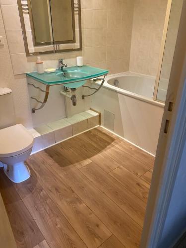 a bathroom with a sink and a toilet and a tub at Appartement cosy - au cœur du bourg in Crozon