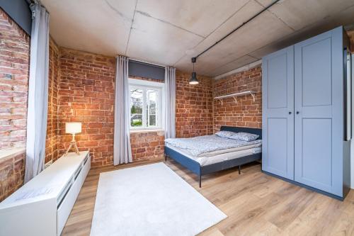a bedroom with a bed and a brick wall at H7 Stuudiokodud- SELF CHECK-IN in Viljandi