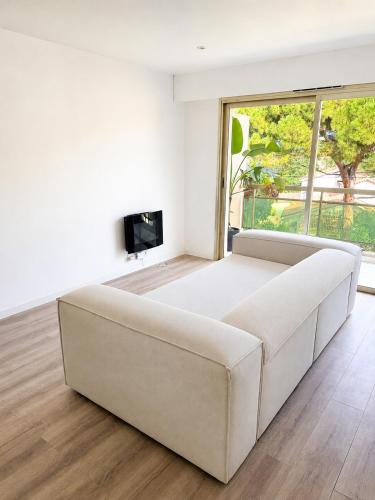 a white couch in a living room with a tv at Cosy Flat Cannes in Le Cannet
