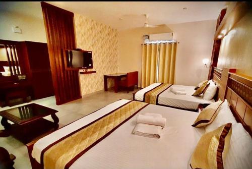 a hotel room with two beds and a television at ROYAL RESIDENCY Ac in Virudunagar