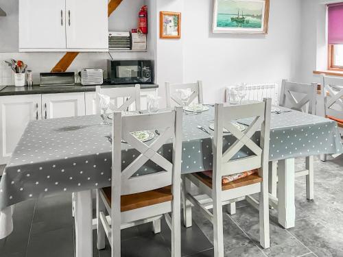 a dining room table with a polka dot table cloth at Stocks Tree Cottage in Preston Wynne
