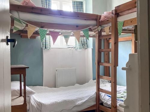 a bedroom with two bunk beds and a window at St James Cottage in Shaftesbury