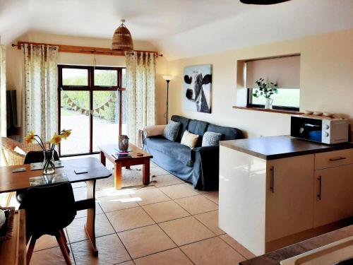 a kitchen and living room with a couch and a table at Harvest Cottage in Anderby