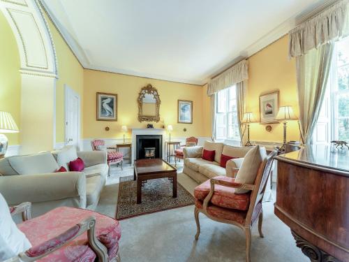 a living room filled with furniture and a fireplace at Kilmichael House in Brodick