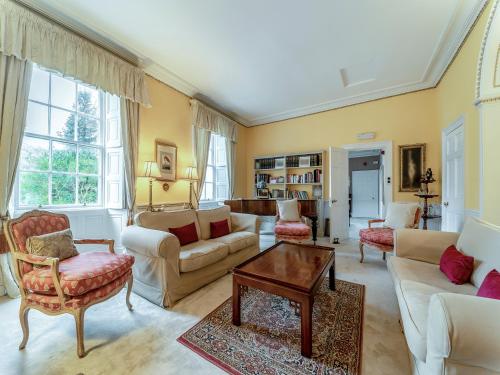 a living room with couches and a table at Kilmichael House in Brodick
