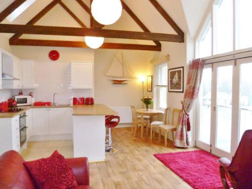 a kitchen and living room with a table and chairs at Watch House in Fowey