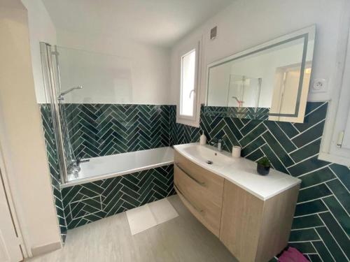 a bathroom with a sink and a shower and a mirror at L'Apart Amiens in Le Treuil