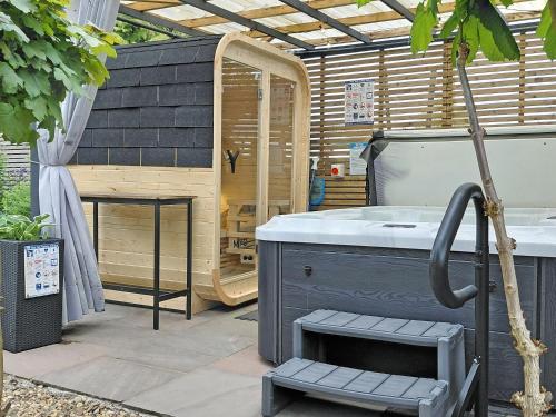 a hot tub in a backyard with a wooden house at Sonny Cottage in Glanamman