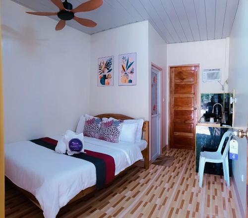 a bedroom with a bed and a ceiling fan at Victoria's Inn in Siquijor