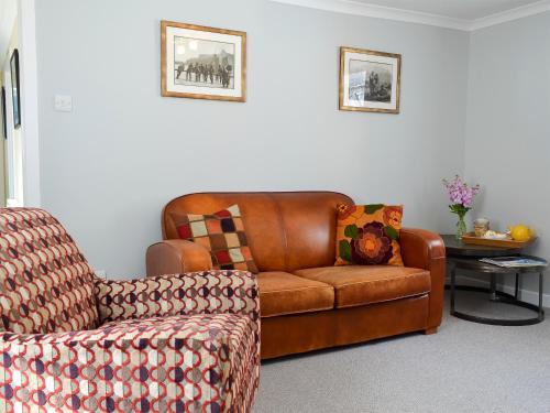 a living room with a couch and a chair at Three Creeks Cottage in Portknockie