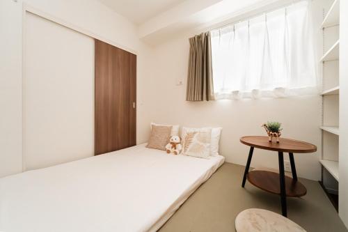 a small bedroom with a bed and a table at Poka Premium Kuramae Luxury 2BR Suite Brand-New in Tokyo