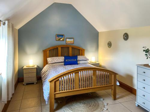 a bedroom with a wooden bed and two lamps at Plough Cottage in Anderby