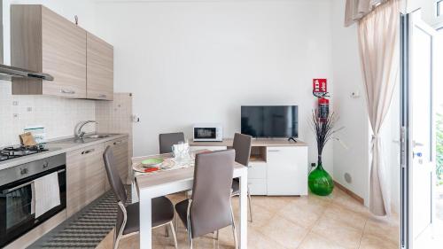 a kitchen with a table and chairs in a kitchen at Casa Alessia by Rentbeat in Cisternino