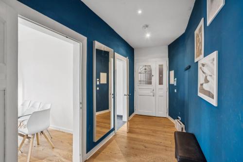 a blue hallway with a chair and a door at Arbio I Modern Apart near Leipzig Stötteritz in Leipzig