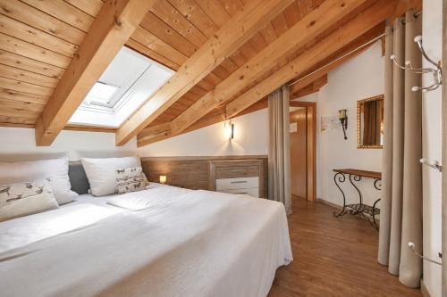 a bedroom with a large white bed with a skylight at Chalet im Haus Schlossblick in Füssen
