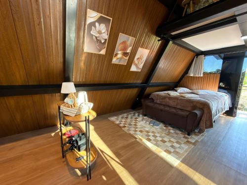 a bedroom with a bed in a room with wooden walls at Cabana Silêncio das Pedras in Três Coroas