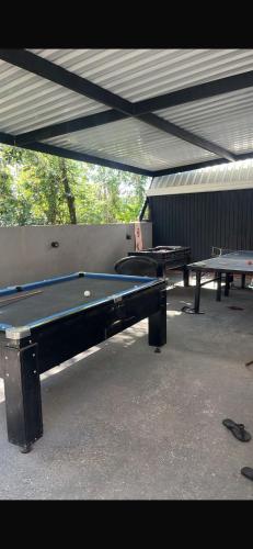 two ping pong tables sitting under a roof at Chácara Bosque da Paz in Ibiúna