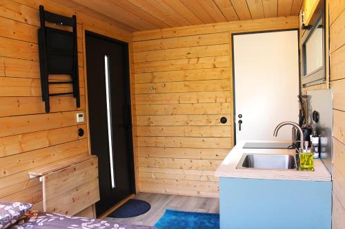 a kitchen with a sink in a wooden room at PRIVAATNE Metsamajake SAUNAGA "KOHIN" in Sigula