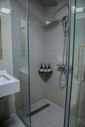 a shower with a glass door next to a sink at Khiimori Hotel in Ulaanbaatar
