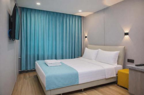 a bedroom with a large bed with a blue curtain at Khiimori Hotel in Ulaanbaatar