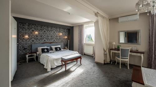 a bedroom with a bed and a desk and a window at Biały Dom Henlex Hotel Restauracja in Poznań
