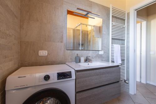a bathroom with a washing machine and a sink at IseoLakeRental - Casa Lani in Costa Volpino