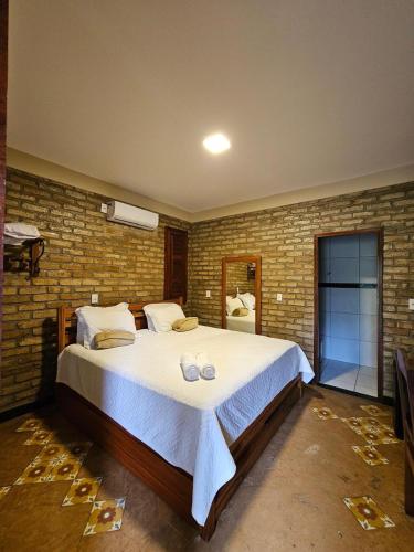a bedroom with a large bed in a brick wall at Sítio do Bosco Park in Tianguá