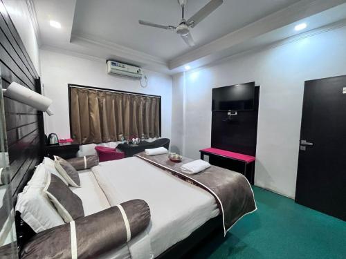 a bedroom with a large bed and a tv at Le-Leisure Hotel in Prayagraj