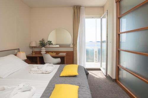a hotel room with a bed and a large window at Hotel Punta in Vodice