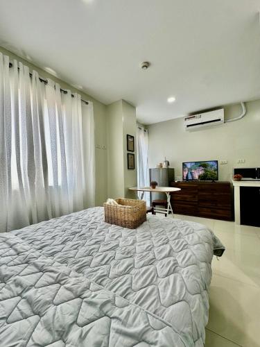 a bedroom with a large bed and a flat screen tv at TWD 716 Cityscape in Bacolod