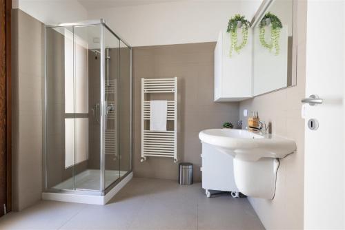 a bathroom with a glass shower and a sink at IseoLakeRental - Casa Cuneo in Costa Volpino