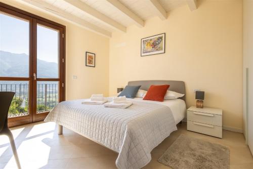 a bedroom with a bed and a large window at IseoLakeRental - Casa Cuneo in Costa Volpino
